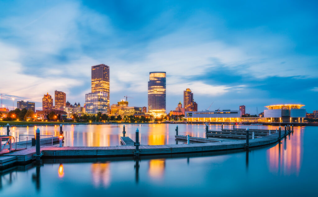 Milwaukee skyline at night with reflection in Lake Michigan.